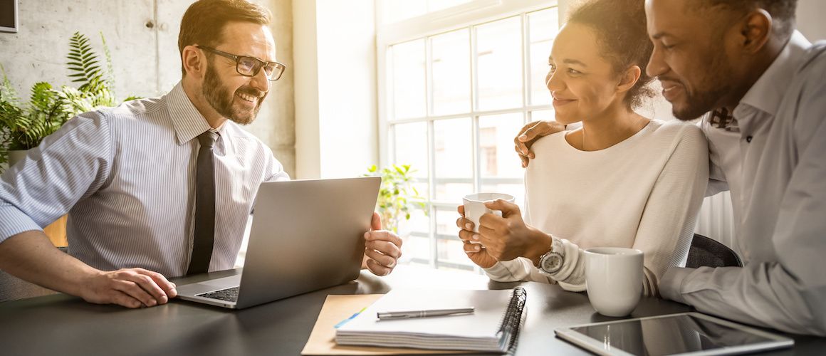 Happy couple meeting financial planner.