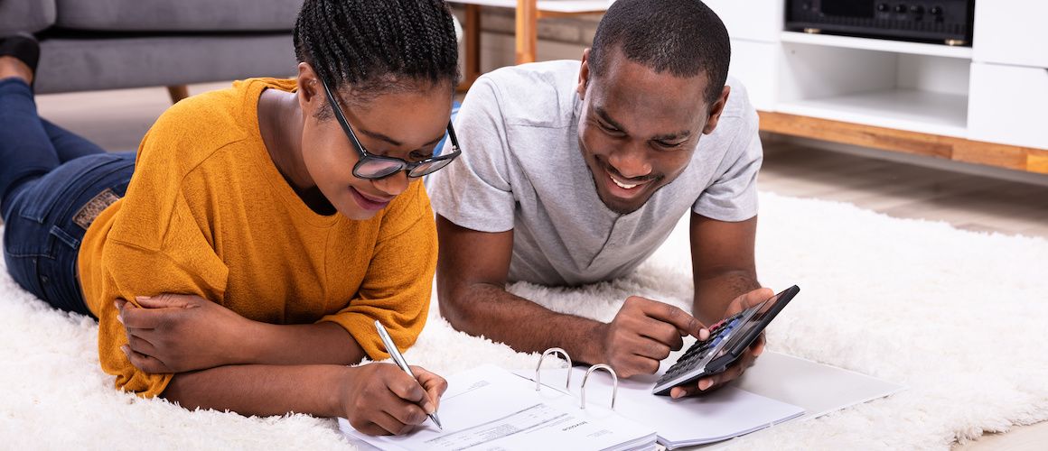 Young couple doing finances on the carpet.